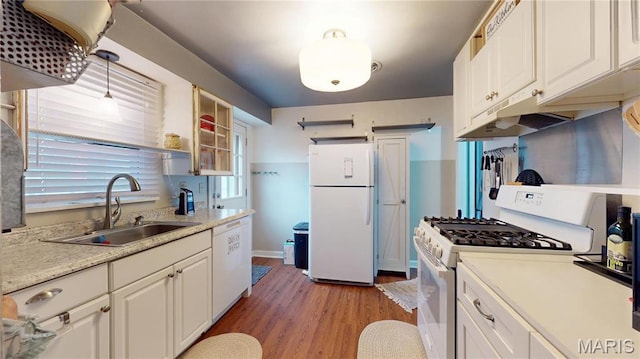 kitchen with white appliances, a sink, white cabinetry, light wood-style flooring, and light countertops
