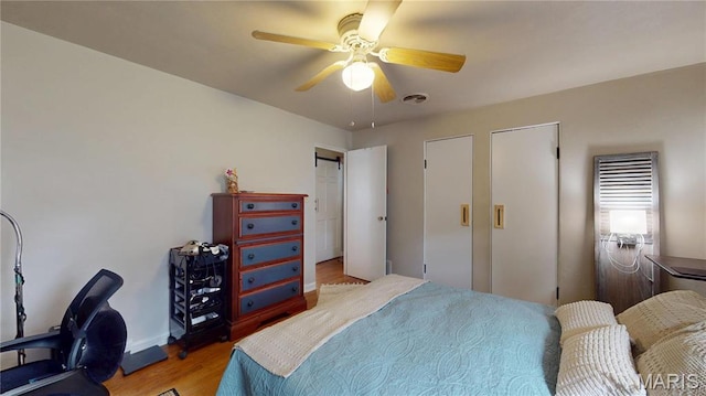 bedroom featuring wood finished floors, a ceiling fan, and baseboards