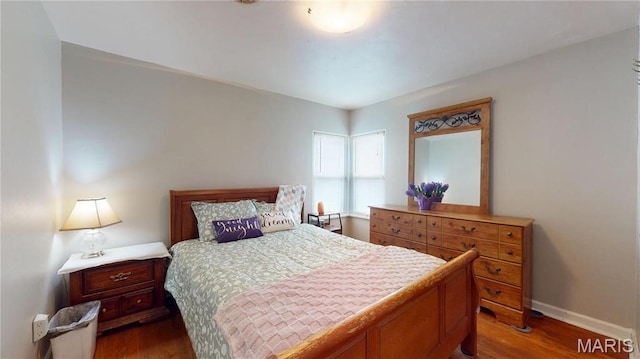 bedroom featuring dark wood-style flooring and baseboards