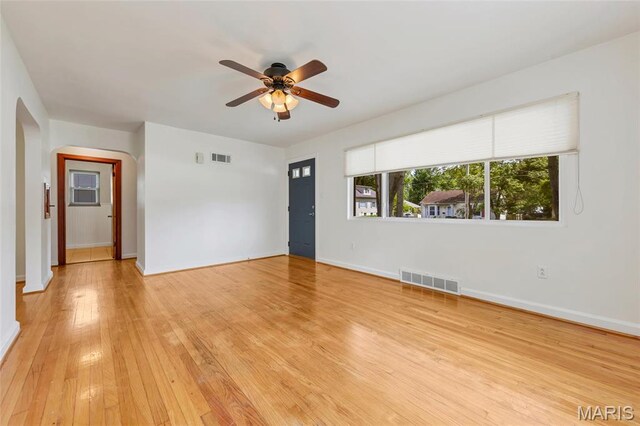 509 N Jefferson St, Mascoutah, IL 62258 - unfurnished living room featuring arched walkways, ceiling fan, light wood-type flooring, and baseboards