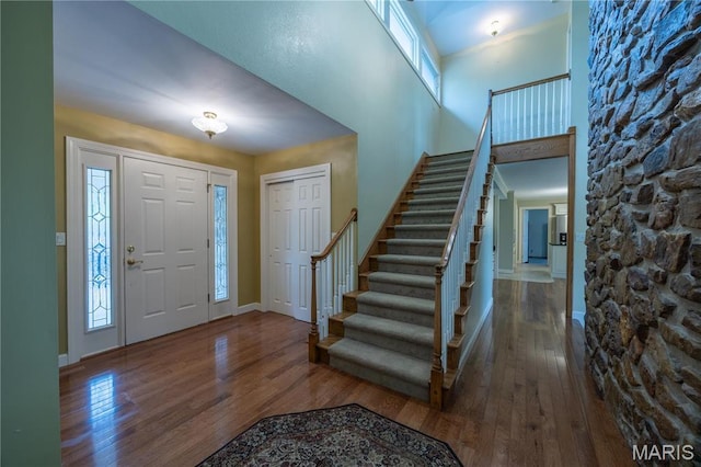 entryway featuring hardwood / wood-style flooring, stairway, and baseboards