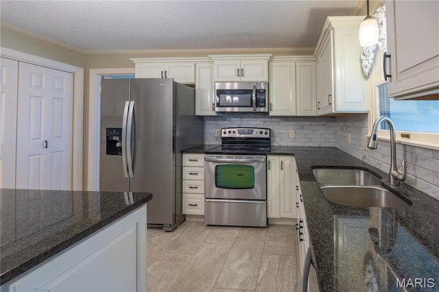 kitchen with stainless steel appliances, a sink, crown molding, backsplash, and white cabinets