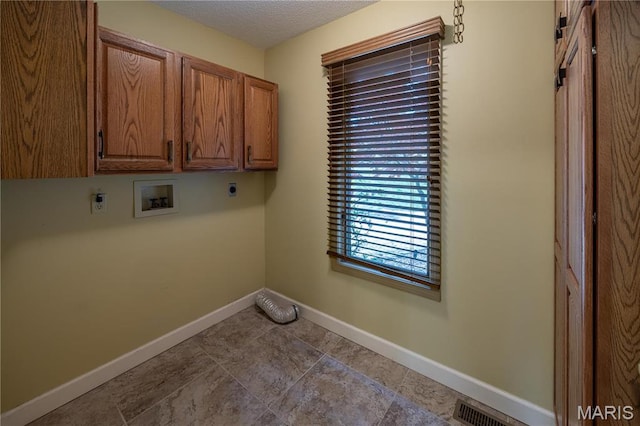 laundry area with electric dryer hookup, washer hookup, cabinet space, baseboards, and a textured ceiling