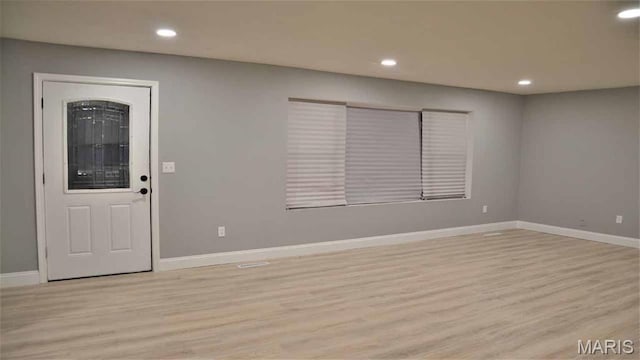 empty room with light wood-type flooring, recessed lighting, and baseboards