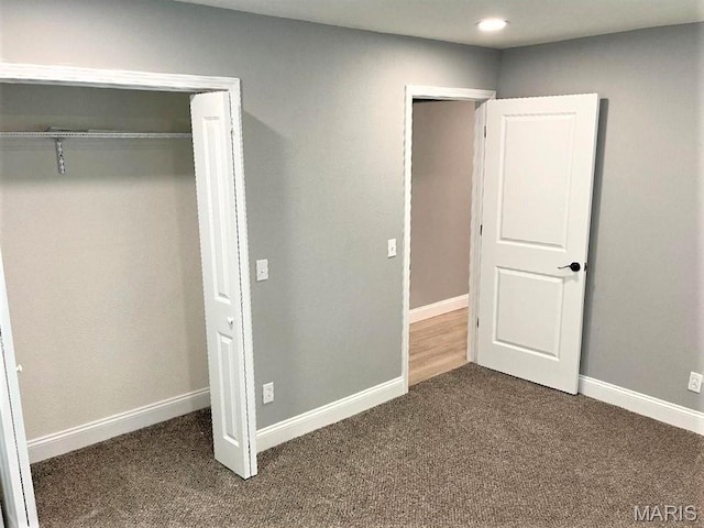 unfurnished bedroom with dark carpet, baseboards, and recessed lighting