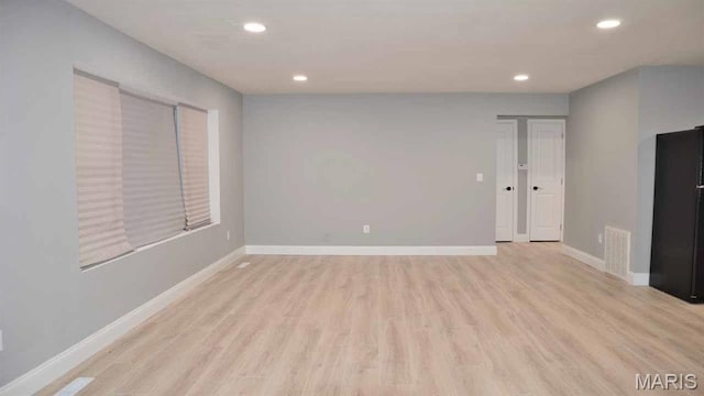 unfurnished living room featuring recessed lighting, light wood finished floors, and baseboards