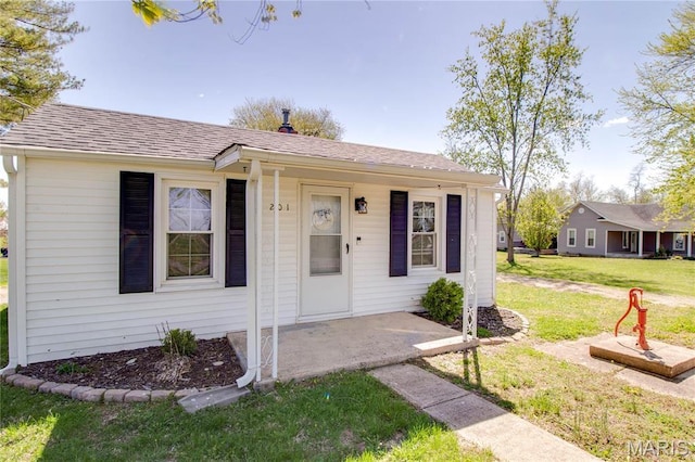 view of front of home with a front yard and roof with shingles