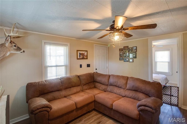 living room with wood finished floors, ceiling fan, crown molding, and baseboards