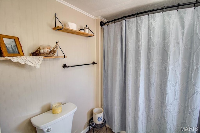 bathroom with crown molding, toilet, and a shower with shower curtain