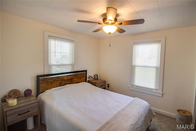 bedroom with multiple windows, carpet flooring, baseboards, and ceiling fan
