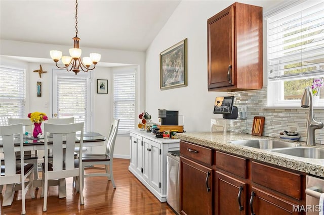 kitchen featuring a sink, a chandelier, dark wood finished floors, tasteful backsplash, and plenty of natural light
