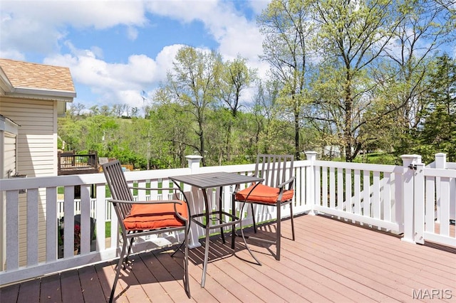 wooden deck featuring view of scattered trees
