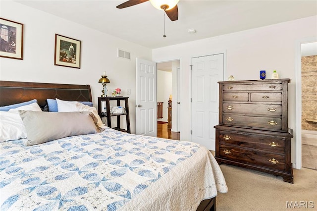 carpeted bedroom featuring ensuite bathroom and a ceiling fan