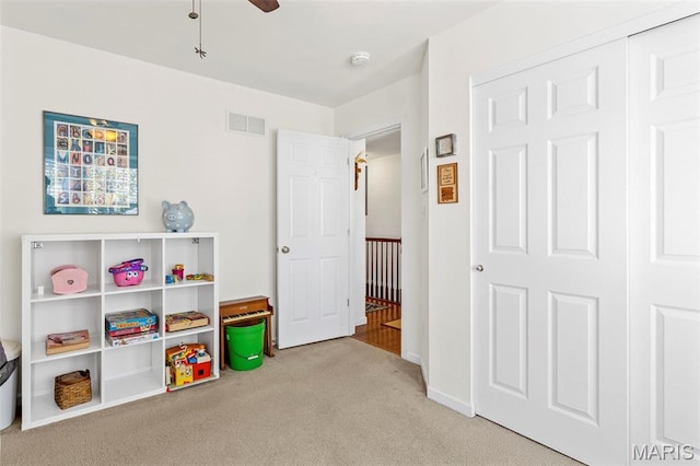 recreation room featuring carpet, a ceiling fan, and baseboards
