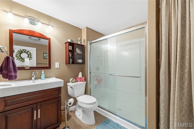 full bath with a stall shower, toilet, tile patterned flooring, vanity, and baseboards