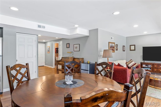 dining room with light wood-style floors, recessed lighting, and baseboards