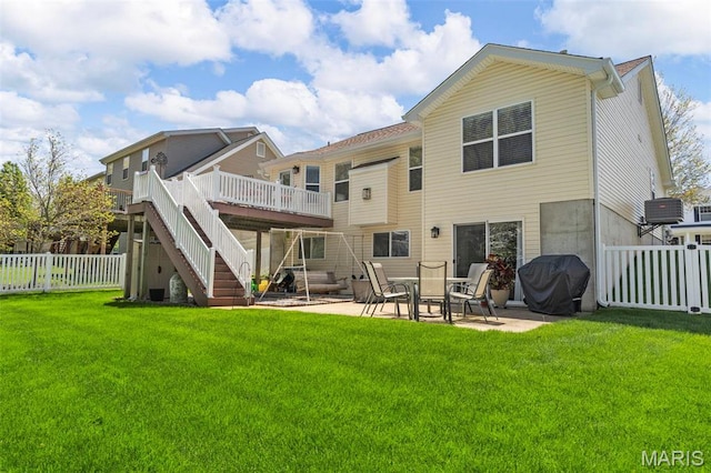 rear view of property with stairway, a wooden deck, and a patio