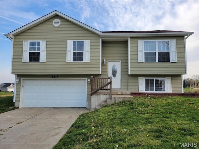 bi-level home with a garage, a front lawn, and driveway