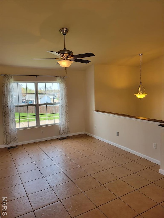 empty room with baseboards, light tile patterned floors, and ceiling fan