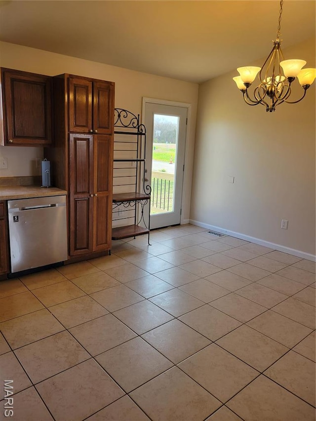 kitchen with stainless steel dishwasher, a chandelier, baseboards, light tile patterned flooring, and light countertops