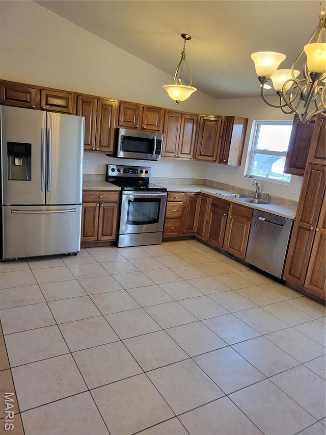 kitchen with appliances with stainless steel finishes, a sink, light countertops, vaulted ceiling, and a chandelier