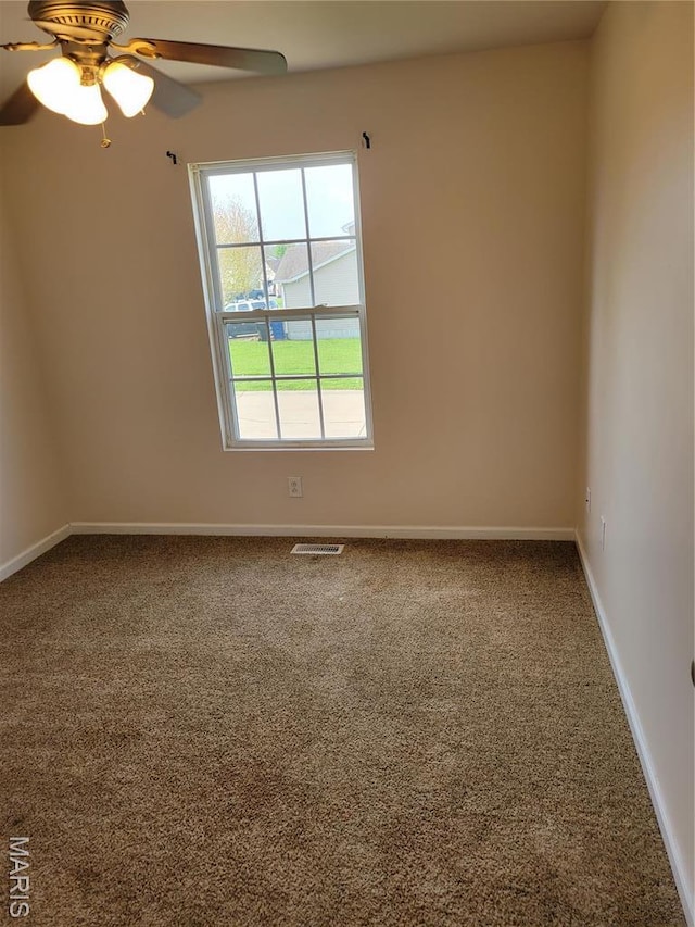 carpeted spare room featuring baseboards and ceiling fan