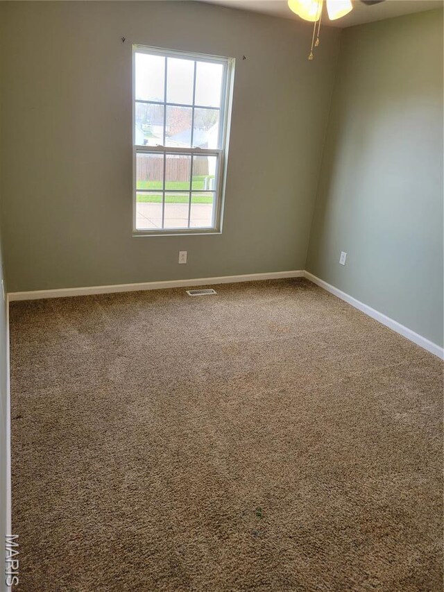 carpeted spare room with baseboards and ceiling fan