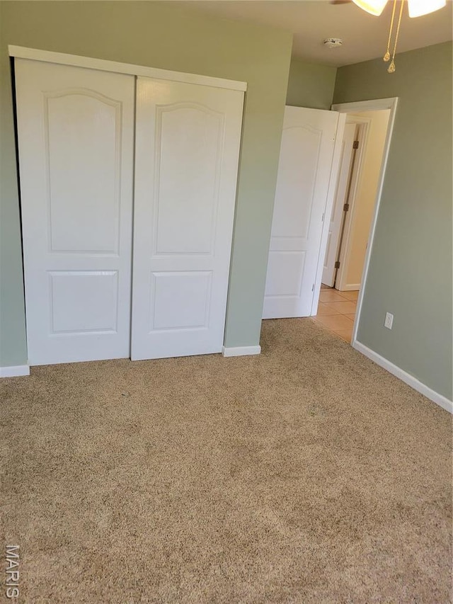 unfurnished bedroom featuring carpet floors, baseboards, and a closet