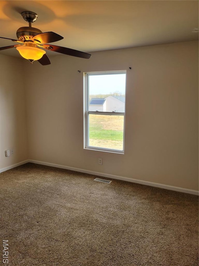 spare room with carpet, baseboards, and ceiling fan