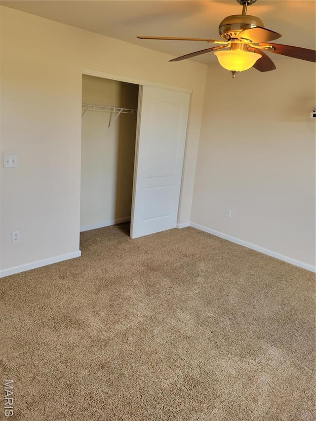 unfurnished bedroom with carpet, a closet, ceiling fan, and baseboards