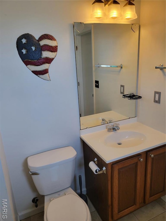 half bathroom featuring toilet, vanity, and tile patterned flooring