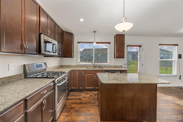 kitchen featuring appliances with stainless steel finishes, a sink, dark wood-style floors, decorative light fixtures, and recessed lighting
