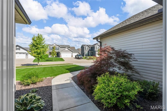 view of grassy yard with a residential view
