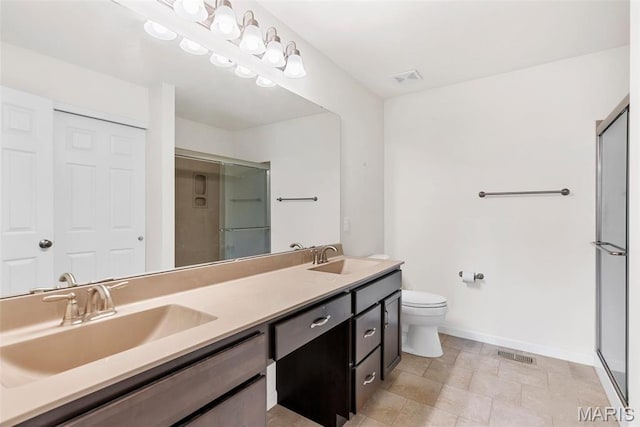 bathroom with a stall shower, baseboards, double vanity, and toilet