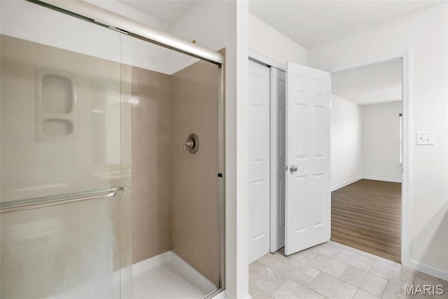 full bathroom featuring a stall shower and baseboards