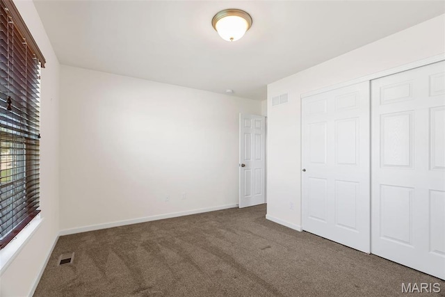 unfurnished bedroom with carpet floors, baseboards, and a closet