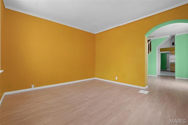 4171 Burgen Ave, Saint Louis, MO 63116 - unfurnished room with light wood-style floors, arched walkways, crown molding, and baseboards