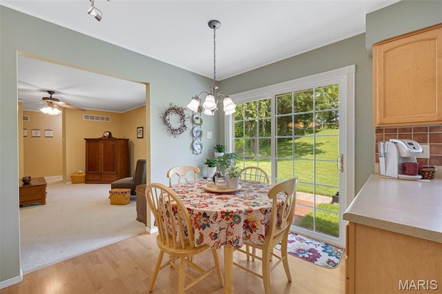 14710 Arbre Ln, Florissant, MO 63034 - dining space featuring light wood finished floors, plenty of natural light, a ceiling fan, and ornamental molding