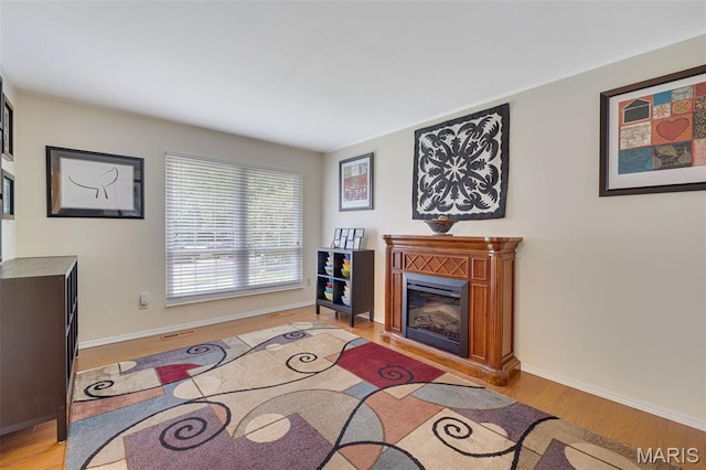14710 Arbre Ln, Florissant, MO 63034 - living area with light wood finished floors, a glass covered fireplace, and baseboards