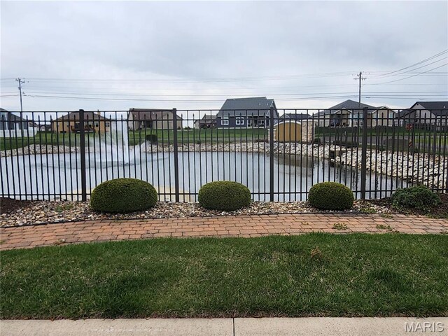 view of pool featuring fence and a water view
