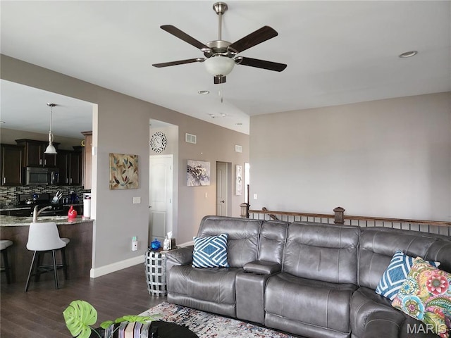 living room featuring a ceiling fan, dark wood-type flooring, baseboards, and recessed lighting