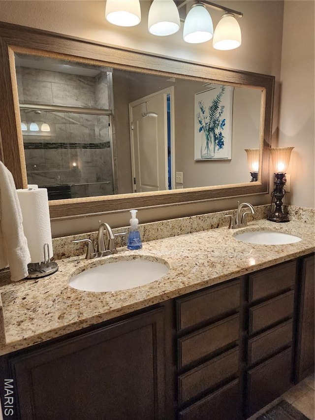 bathroom with a shower stall and double vanity