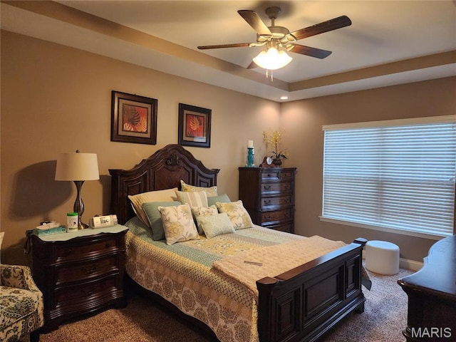 bedroom with carpet floors, a ceiling fan, and a raised ceiling