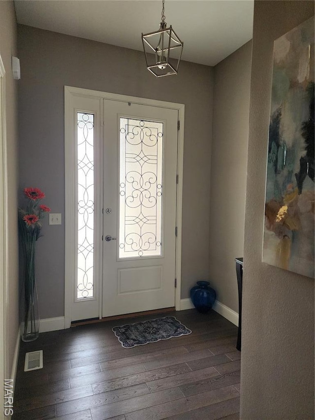 entryway with dark wood finished floors and baseboards
