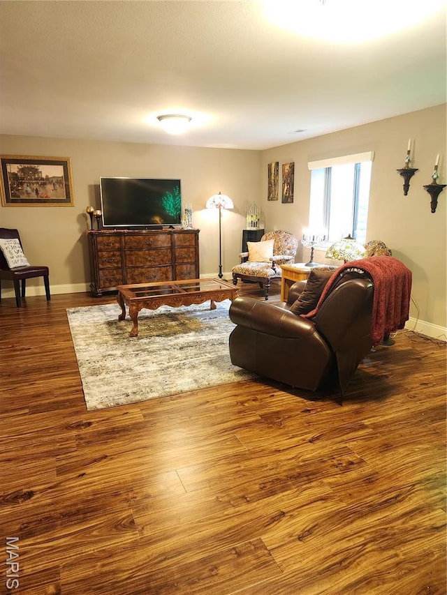 living area with wood finished floors and baseboards