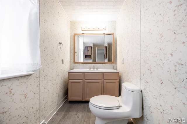 917 N Church St, Belleville, IL 62220 - bathroom with wood finished floors, wallpapered walls, toilet, and vanity