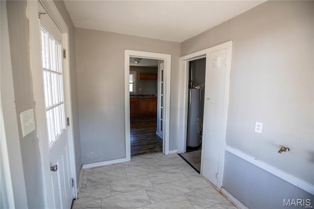 228 B Pine St, Sullivan, MO 63080 - corridor with water heater, plenty of natural light, light marble finish floors, and baseboards