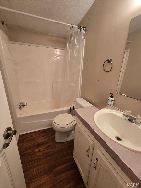 119 Bethel Rd, Hawk Point, MO 63349 - bathroom featuring vanity, wood finished floors, toilet, shower / bath combo, and a textured ceiling