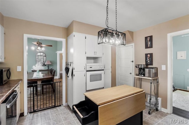 528 Hillsboro Ave, Edwardsville, IL 62025 - kitchen with appliances with stainless steel finishes, a ceiling fan, white cabinets, hanging light fixtures, and baseboards