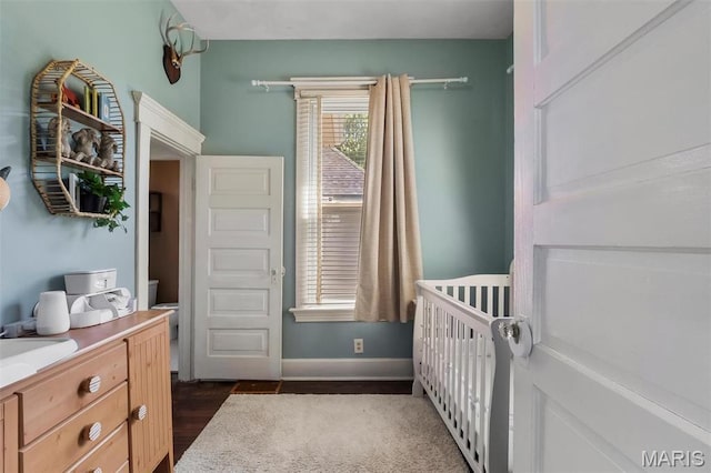 528 Hillsboro Ave, Edwardsville, IL 62025 - bedroom featuring dark wood-type flooring, a nursery area, and baseboards